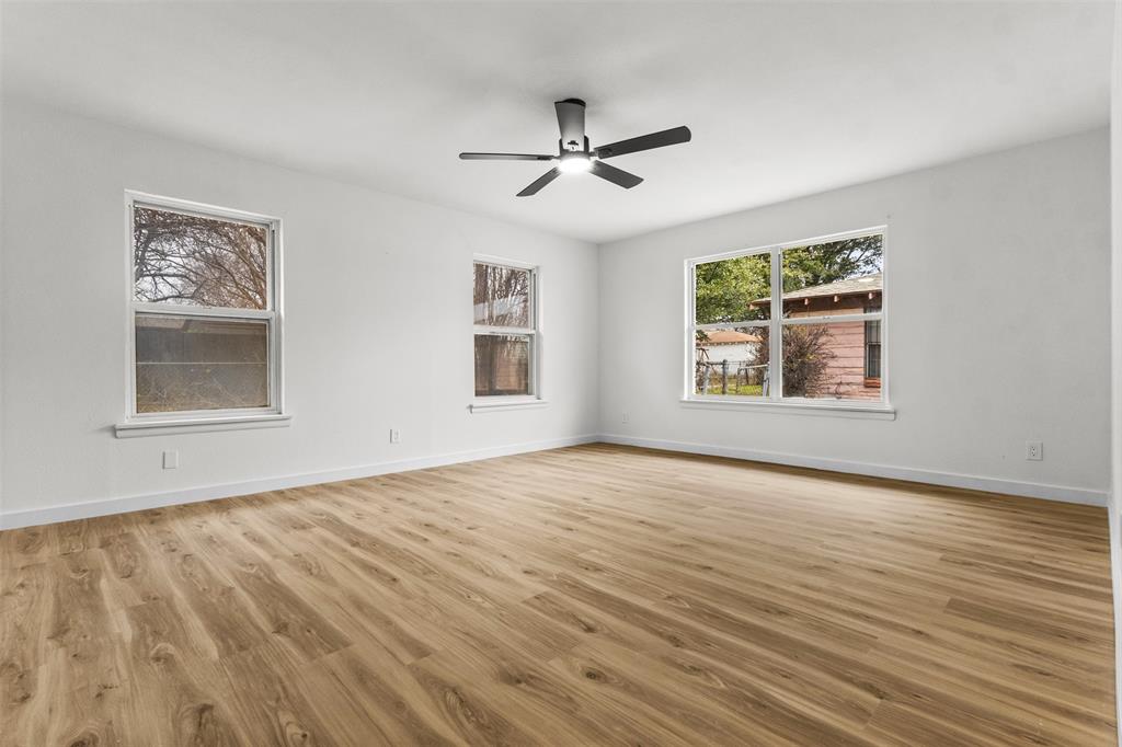 1917 South Vernon Avenue Dallas, TX 75224 - Photo 25 of 28 Spacious room featuring wood-finish flooring, white baseboards, and a contemporary ceiling fan with integrated lighting