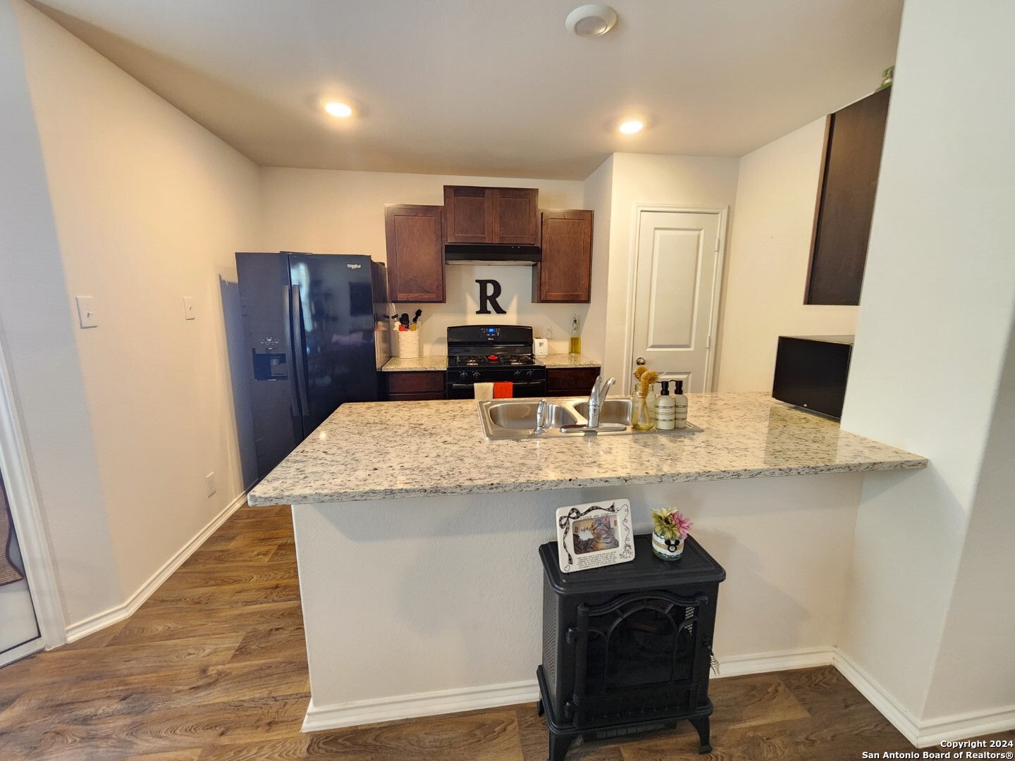 6619 Dynamic Sound San Antonio, TX 78252 - Photo 12 of 20 a kitchen with granite countertop kitchen island stainless steel appliances a sink and refrigerator