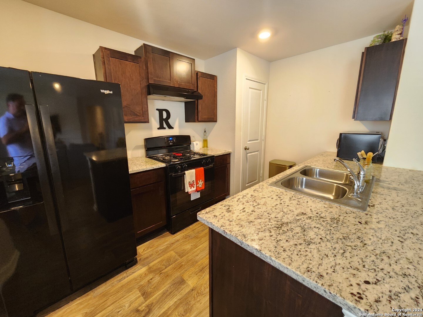 6619 Dynamic Sound San Antonio, TX 78252 - Photo 14 of 20 a kitchen with stainless steel appliances kitchen island granite countertop a refrigerator a stove and a sink