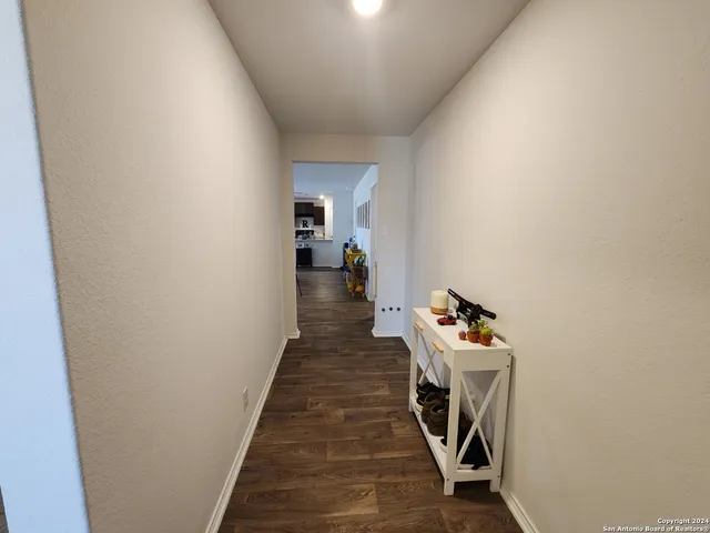 a living room with furniture a flat screen tv and kitchen view