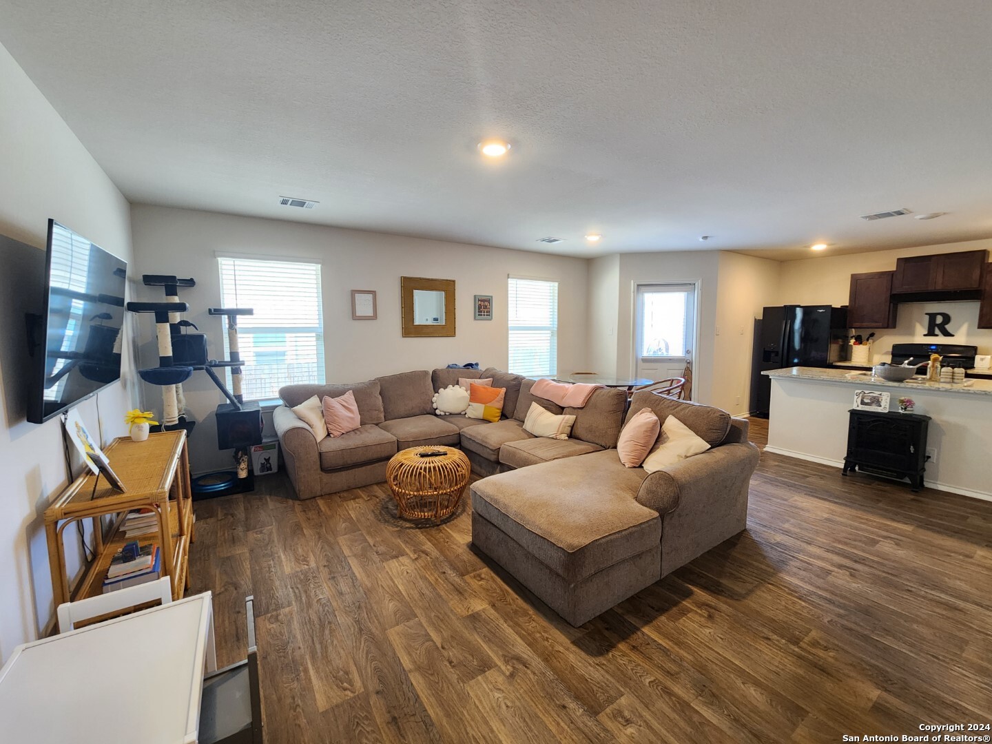 6619 Dynamic Sound San Antonio, TX 78252 - Photo 9 of 20 a living room with furniture a flat screen tv and kitchen view