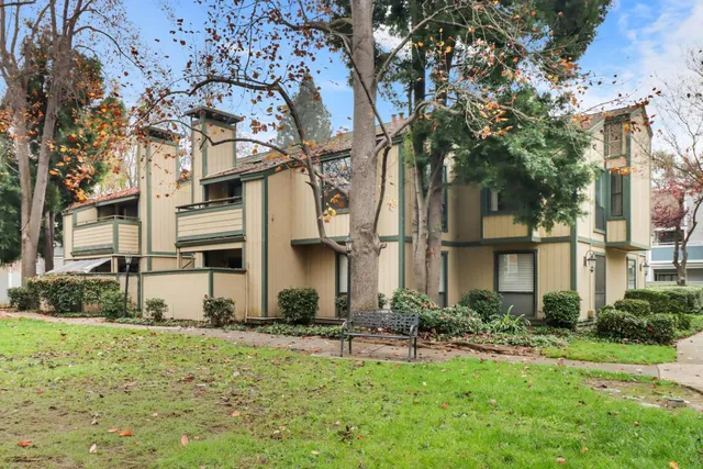 a view of a white house with a yard and plants