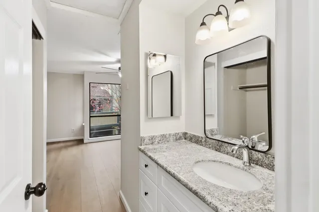 a bathroom with a granite countertop sink and a mirror