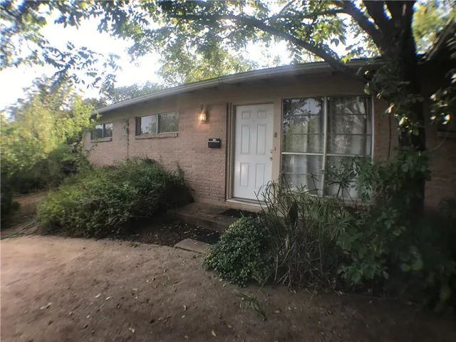 a backyard of a house with plants and trees