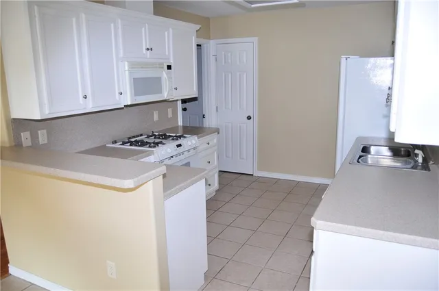 a kitchen with granite countertop a sink a stove and refrigerator