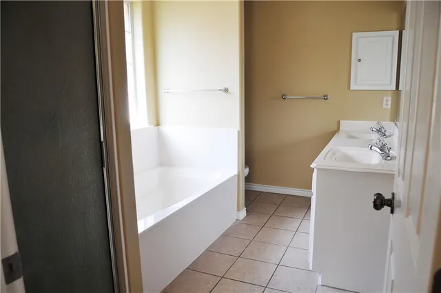a bathroom with a bathtub sink and mirror