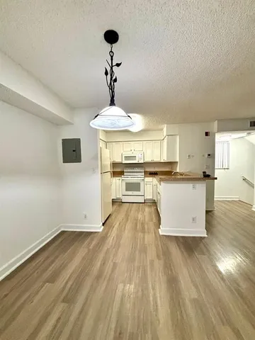 a view of a kitchen with wooden floor and a sink