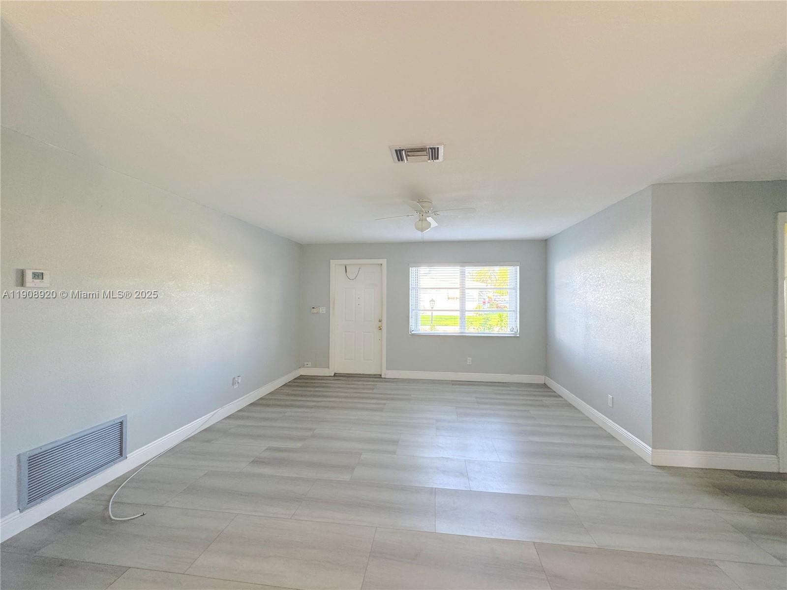 300 Northwest 28th Court Pompano Beach, FL 33064 - Photo 6 of 30 an empty room with wooden floor and windows