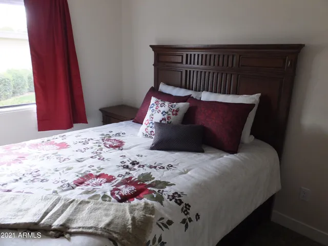 a bed sitting in a bedroom next to a window