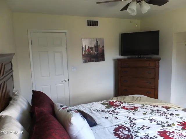 a bedroom with a bed and a flat screen tv