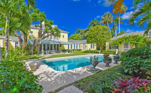 a front view of a residential houses with yard and green space