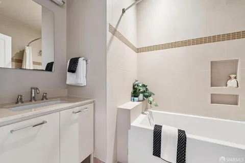 a bathroom with a granite countertop sink a mirror and shower