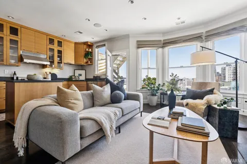 a living room with furniture kitchen view and a window