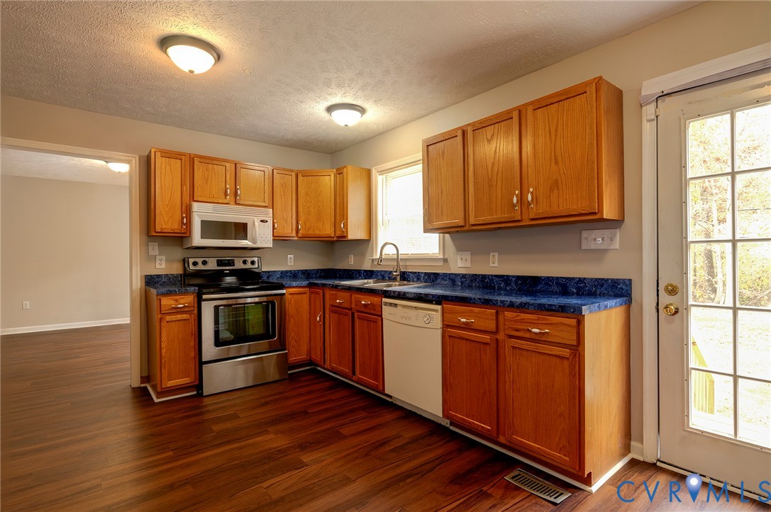 1525 Clarkson Road Richmond, VA 23224 - Photo 3 of 19 a kitchen with stainless steel appliances granite countertop wooden cabinets a stove a sink and a window