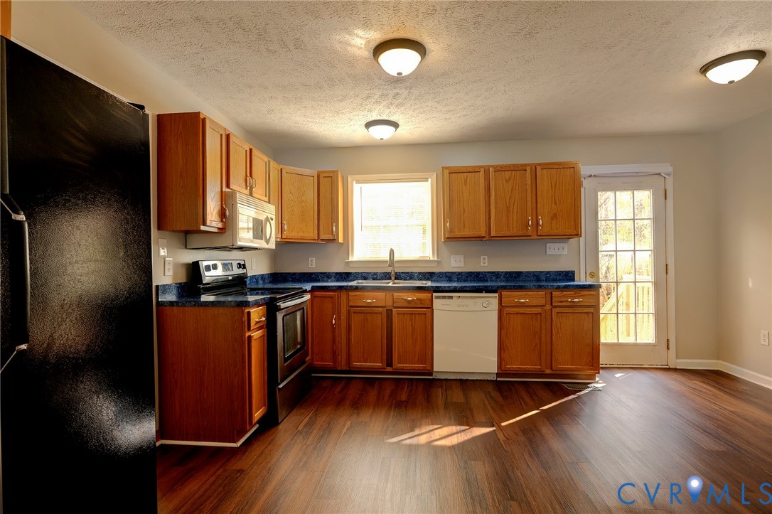 1525 Clarkson Road Richmond, VA 23224 - Photo 4 of 19 a kitchen with granite countertop wooden floors a stove and a microwave