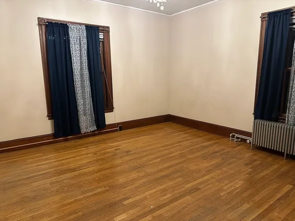 an empty room with wooden floor and a window