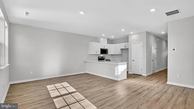 a large white kitchen with a refrigerator and white cabinets