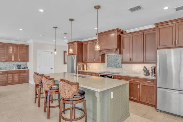 a kitchen with granite countertop wooden cabinets and a refrigerator