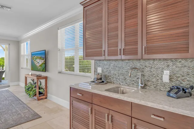 a kitchen with stainless steel appliances granite countertop a sink a oven a dining table and chairs