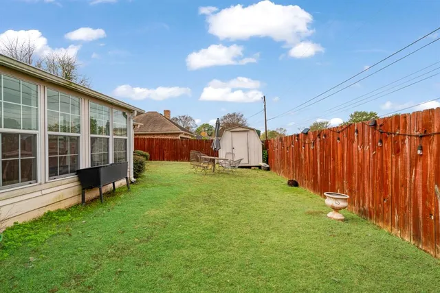 a view of a backyard with wooden fence