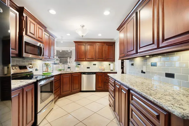 a kitchen with stainless steel appliances granite countertop a sink stove microwave and cabinets