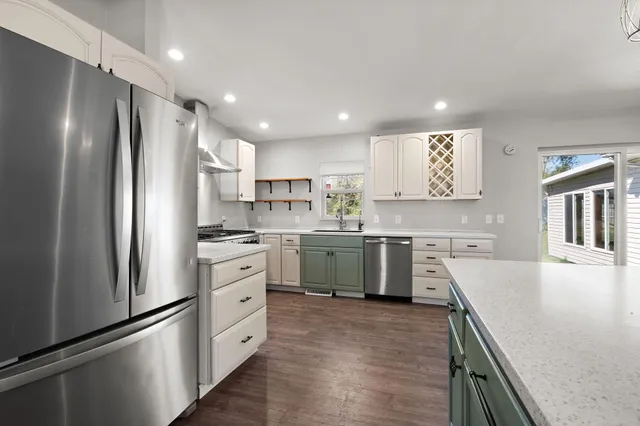 a kitchen with a refrigerator a sink and cabinets