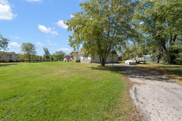 a front view of a house with a garden and trees