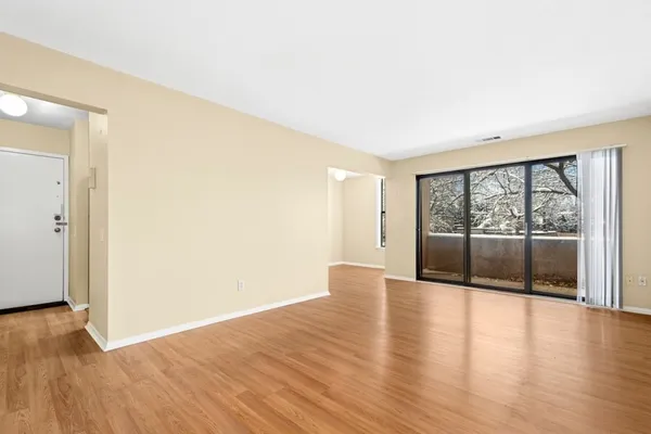 an empty room with wooden floor and window