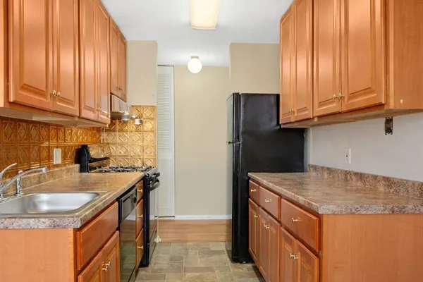 a kitchen with stainless steel appliances granite countertop a stove a sink and a refrigerator