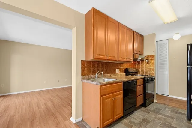 a kitchen with stainless steel appliances granite countertop a refrigerator and a stove top oven