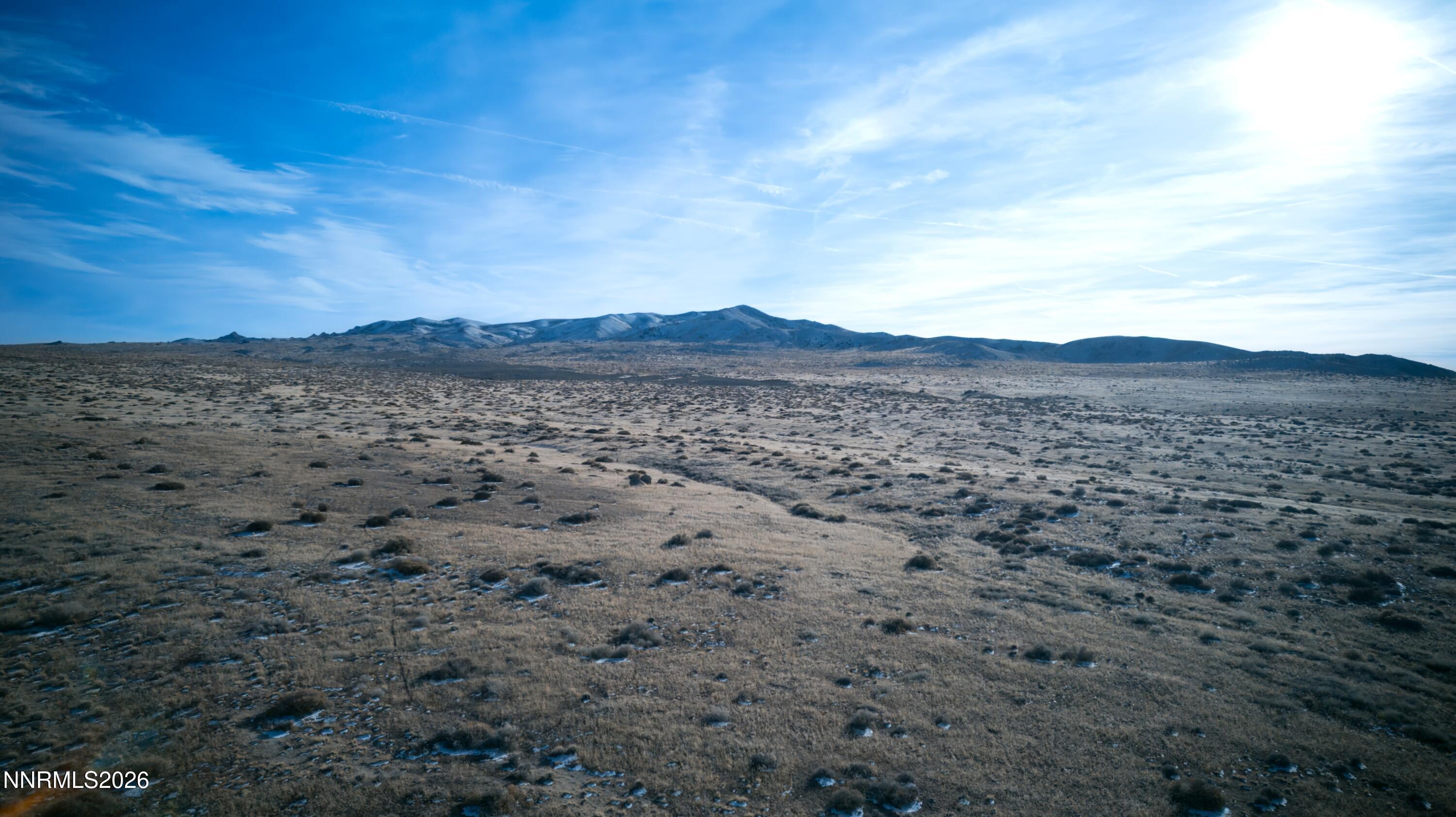 a view of a large mountain with mountains in the background