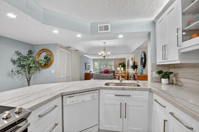 a kitchen with white cabinets and chandelier