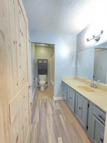 a spacious bathroom with a granite countertop sink a mirror and a bathtub