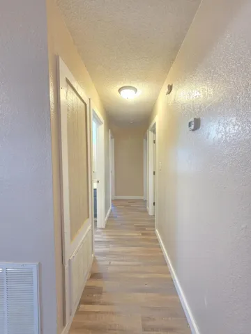 a view of a hallway with wooden floor and staircase