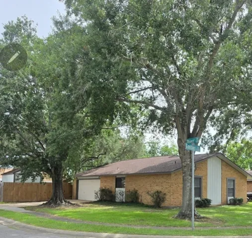 a front view of a house with a garden and trees