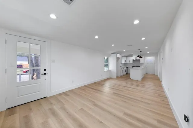 a view of an empty room with wooden floor