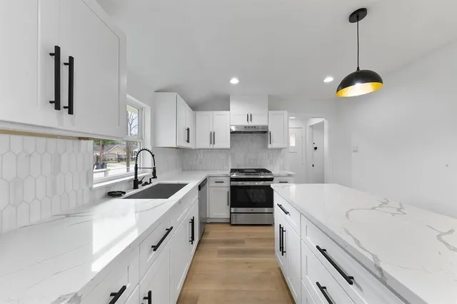 a kitchen with stainless steel appliances a sink stove and cabinets