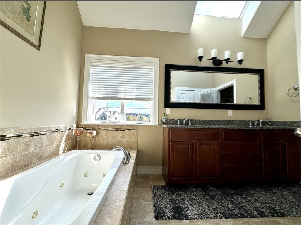 34 Adams Road Grafton, MA 01519 - Photo 19 of 30 a bathroom with a bathtub mirror and a sink