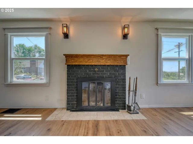 a view of an empty room with window and fire place