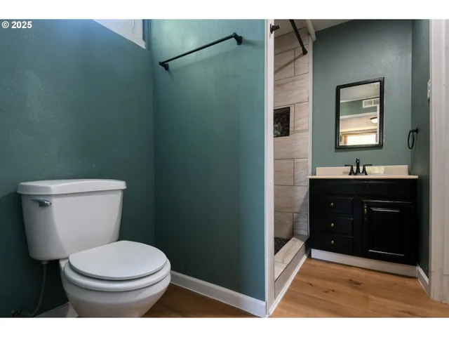 a bathroom with a toilet a sink a vanity and mirror