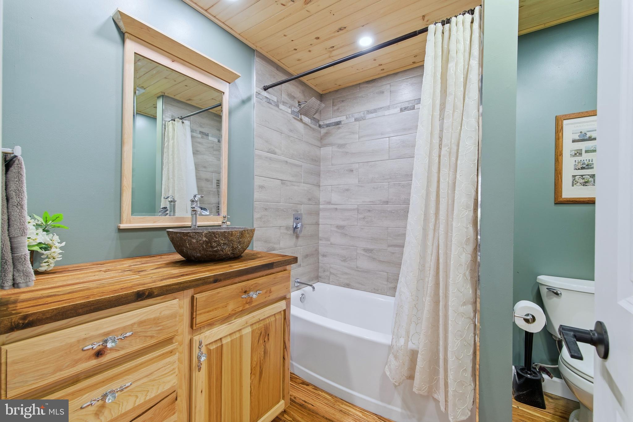 5911 Smith Creek Road New Market, VA 22844 - Photo 32 of 78 a bathroom with a granite countertop sink a mirror and a bathtub