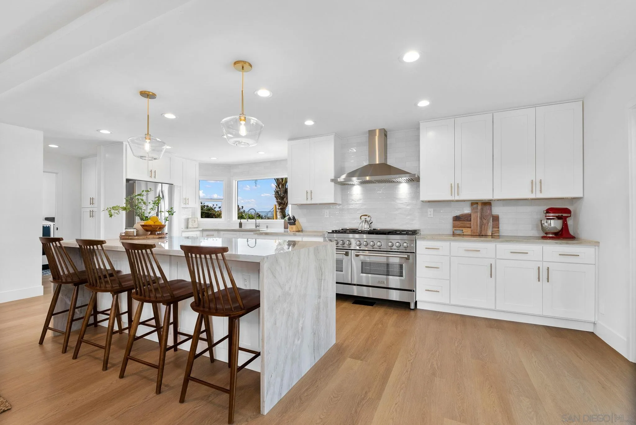 3168 Alta Verde Drive Fallbrook, CA 92028 - Photo 17 of 67 a kitchen with stainless steel appliances granite countertop a stove top oven a sink dishwasher and a dining table with wooden floor
