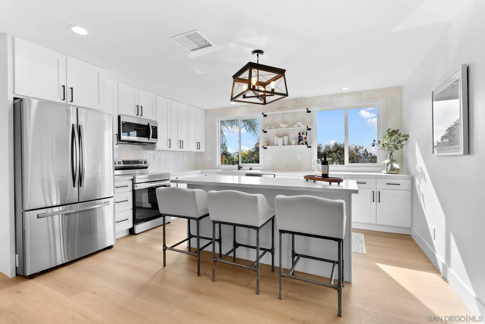 3168 Alta Verde Drive Fallbrook, CA 92028 - Photo 64 of 67 a kitchen with stainless steel appliances granite countertop a dining table chairs refrigerator and sink