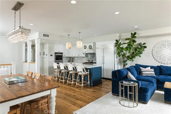 a kitchen with stainless steel appliances a dining table chairs and a refrigerator