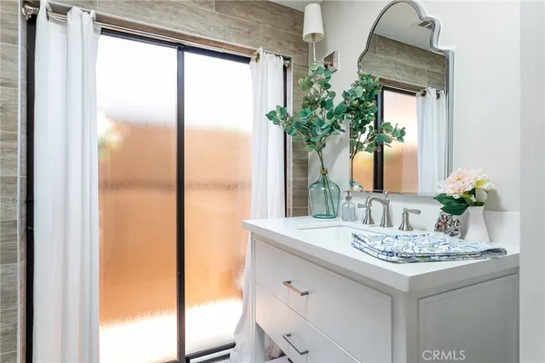a bathroom with a granite countertop sink and a mirror