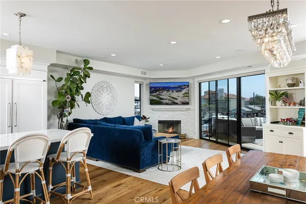 a living room with furniture kitchen view and a chandelier