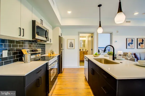 a kitchen with stainless steel appliances a sink a stove and a wooden floors