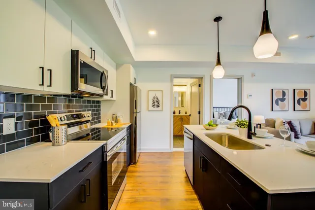 a kitchen with stainless steel appliances a sink stove and refrigerator