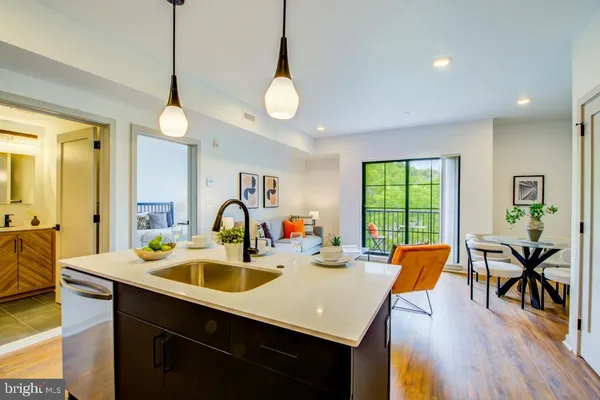 a kitchen with stainless steel appliances a table chairs sink and wooden floor
