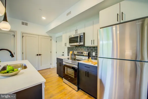 a kitchen with stainless steel appliances granite countertop a refrigerator a stove a sink dishwasher and a refrigerator